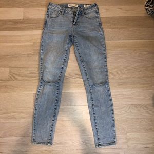 Bullhead mid rise ripped at knee skinny jeans.